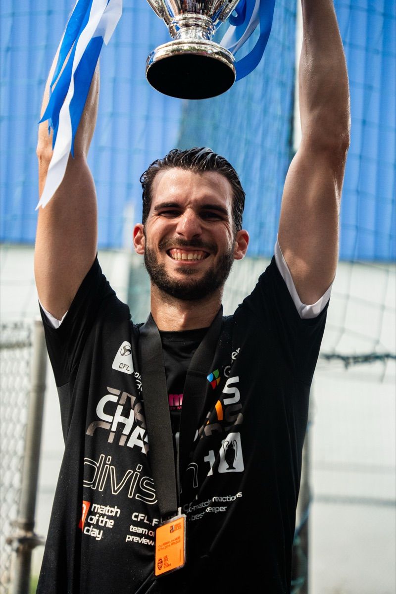 Player hoisting the CFL trophy overhead with his champions medal on