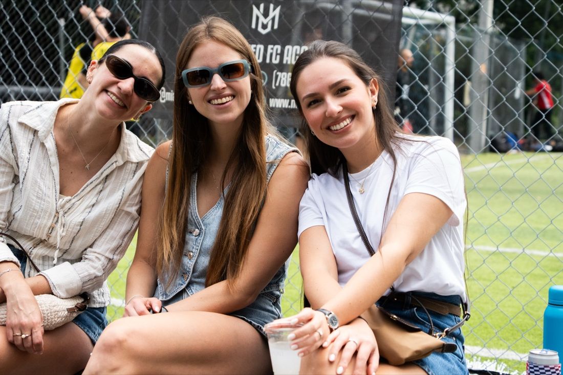Fans laughing pitchside at a Corporate Fútbol League Family Fest